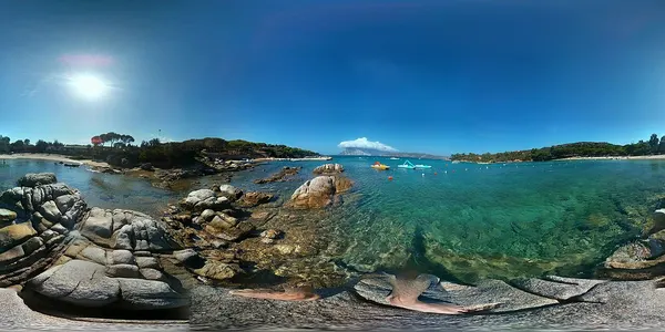 Panorama della riva di Cala Suaraccia con rocce, mare e spiaggia.